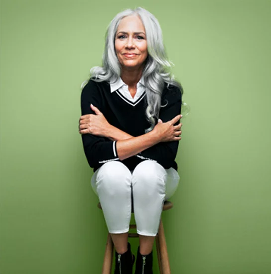 Middle aged woman embracing herself on stool