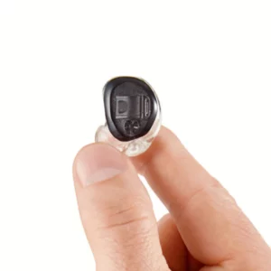 Custom, molded SoundGear Silver ear plug held between thumb and finger. 