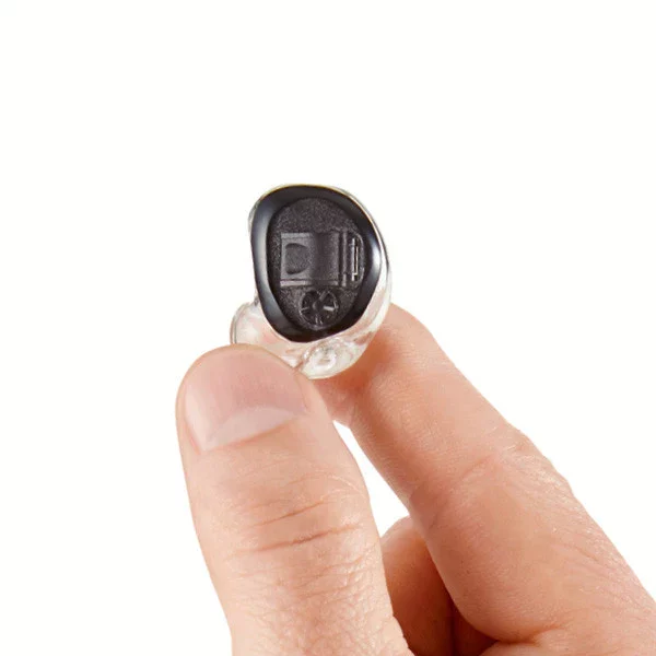 Custom, molded SoundGear Silver ear plug held between thumb and finger.