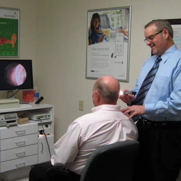 Hearing specialist examining patient's ear