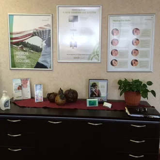 Office counter with hearing infographics hanging on wall