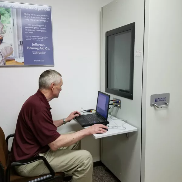 Hearing specialist working on office computer