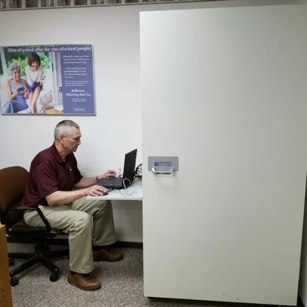 Hearing specialist working on office computer