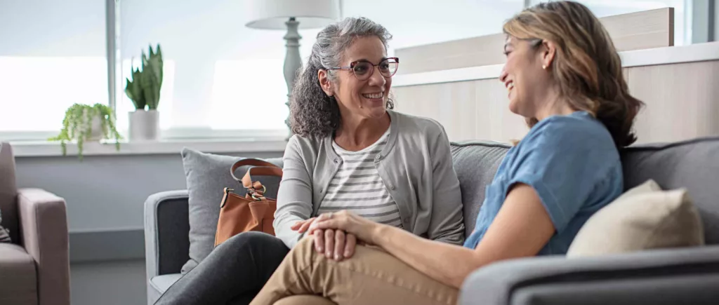 Two women talking while sitting on a couch