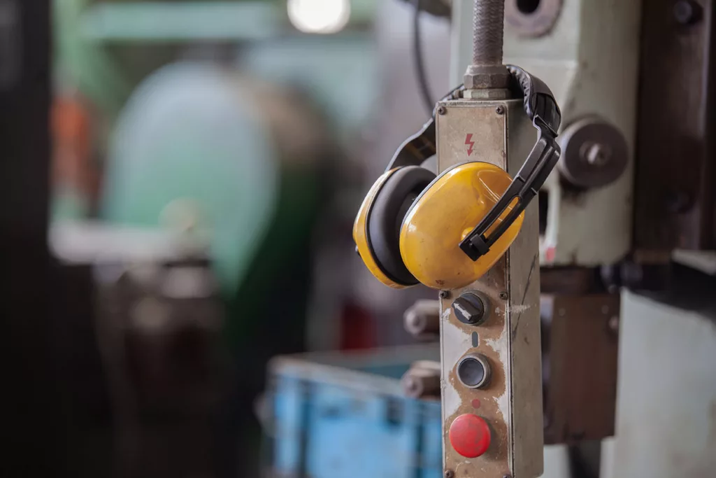 ear protection muffs hanging on switch for large machinery