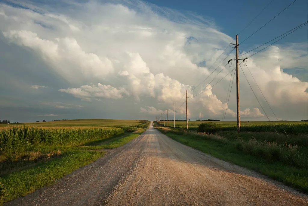 desolate rural, gravel road stretching out to the horizon on a cloudy day 