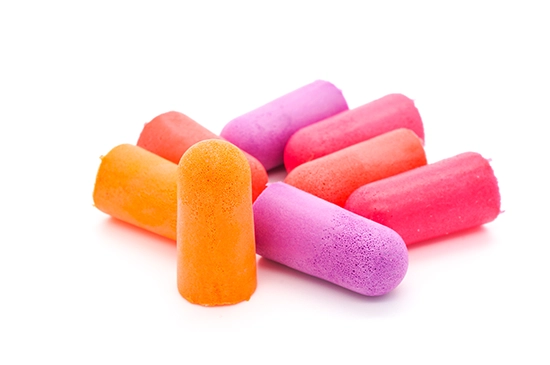 Multiple pairs of brightly colored disposable earplugs made of foam.