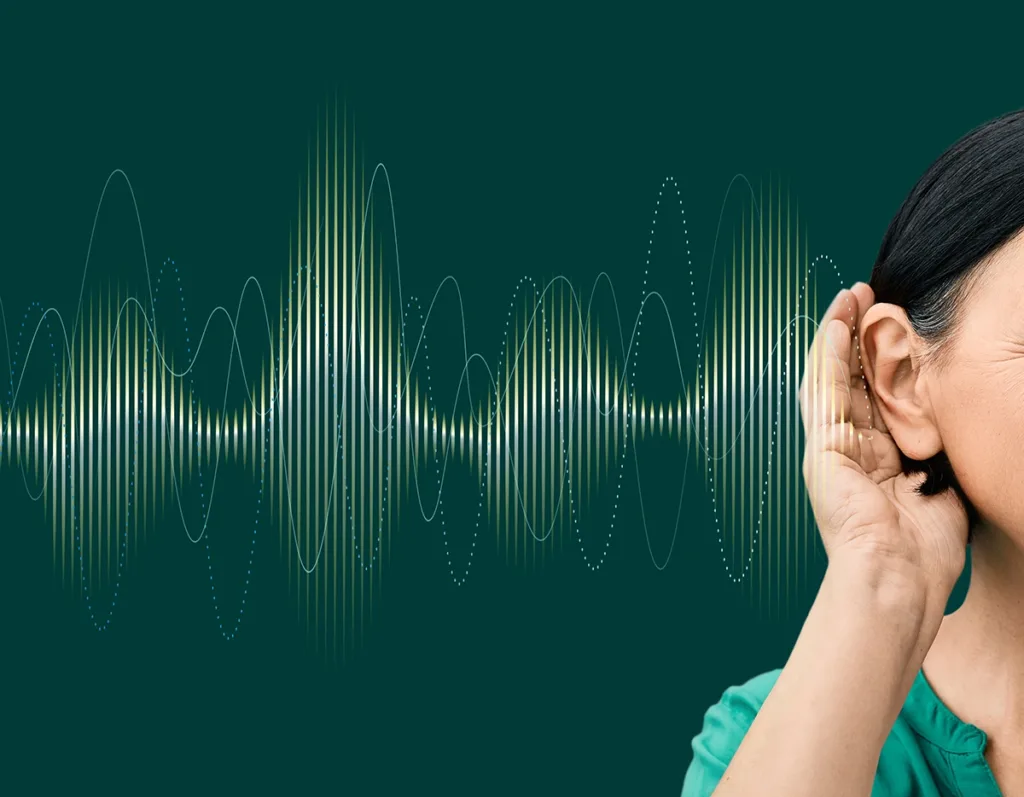 Close up of a woman wearing behind the ear AI hearing aid with sound waves pattern in foreground, concept for AI hearing aid technology