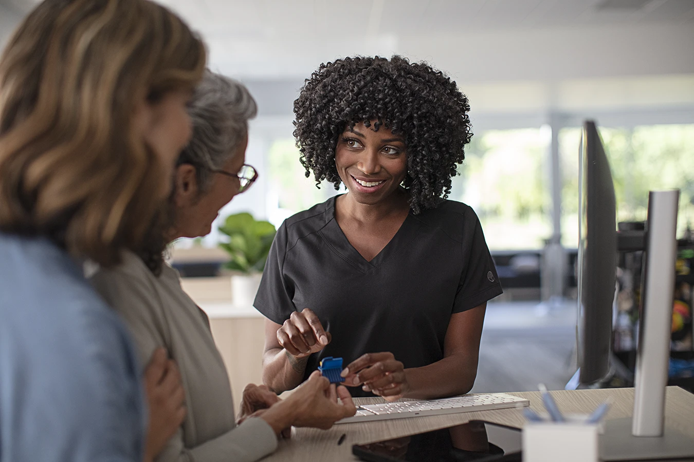 A hearing care specialist explaining daily hearing aid cleaning and care to a patient