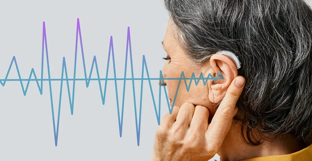 Mature woman with hearing aid on light background, closeup