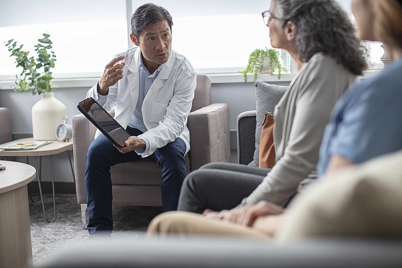 A hearing care specialist holding a tablet as he explains to a patient What Hearing Aid Acclimatization is