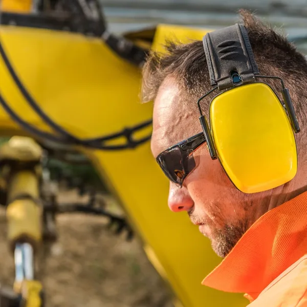 Side profile of a construction worker wearing hearing protection to prevent occupational hearing loss