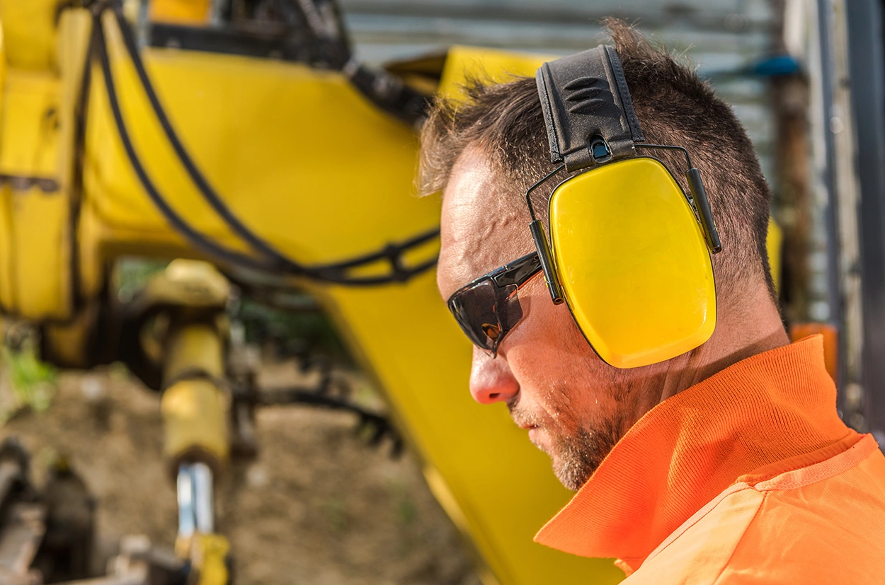 Side profile of a construction worker wearing hearing protection to prevent occupational hearing loss