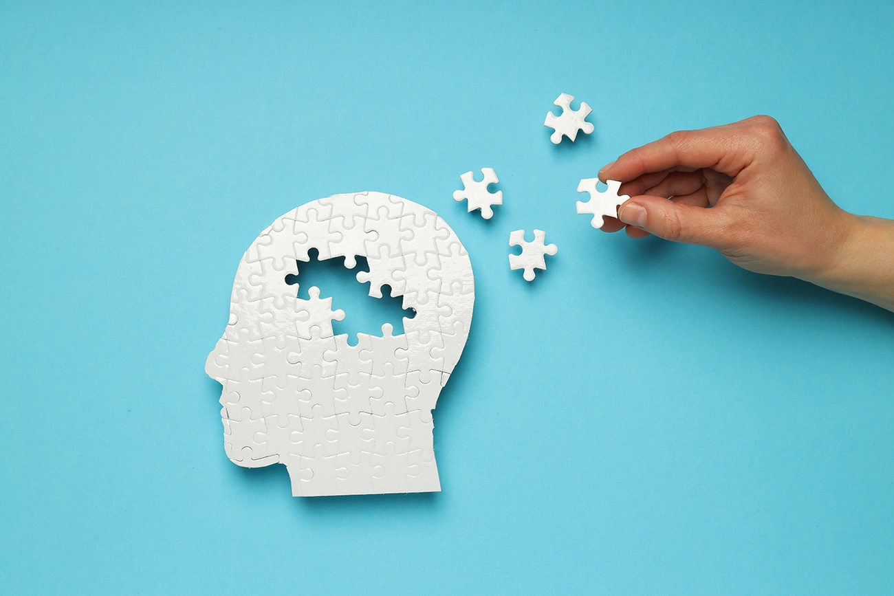 A puzzle in the shape of a brain with some missing pieces, symbolizing the concept of hearing loss and Alzheimer's disease.